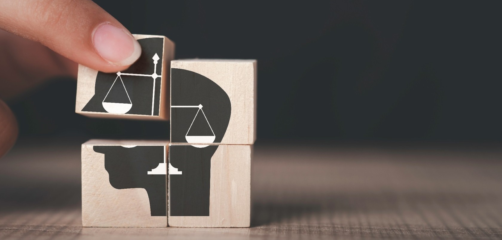 Ethics inside human mind, Business ethics concept. Hand hold ethics inside a head symbols in wooden cubes on dark background with copy space.